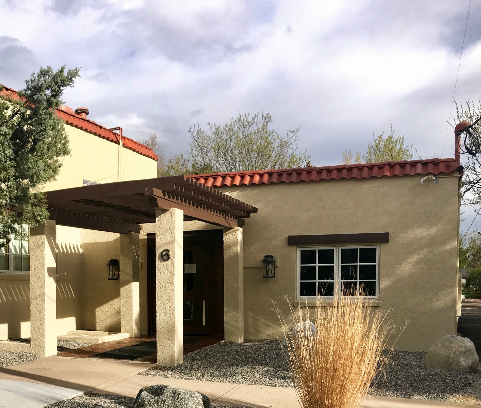 Exterior of Dr. Dalsaso's Colorado Springs office at 6 Elm Ave, a stucco building with a red tile roof and pergola entry